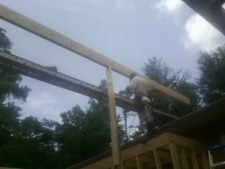 Carpenter setting a ridge beam over a new addition frame — Ice Dam Removal by Roofing Brothers in Beechmont